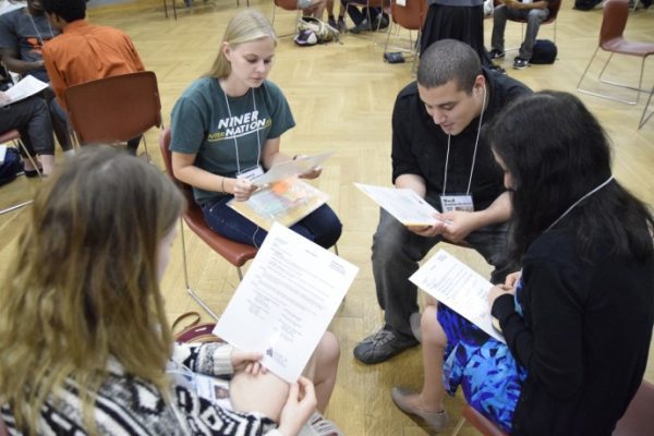 Students in group reading papers