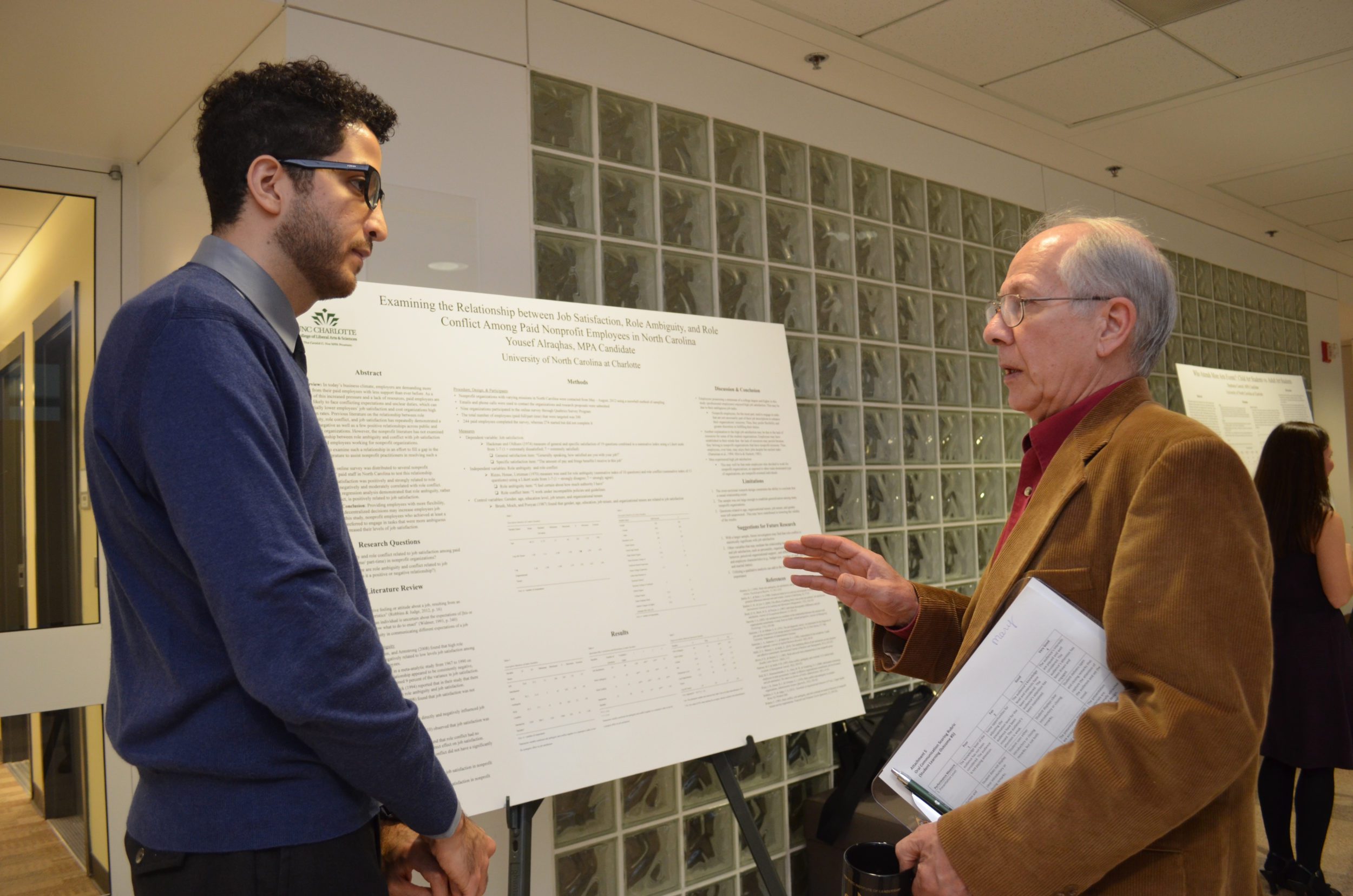 Faculty guide students in poster presentation