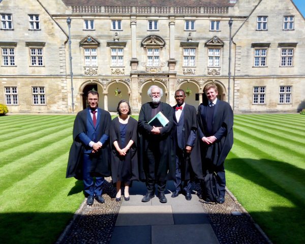 Akin Ogundiran on the lawn at University of Cambridge with dignitaries