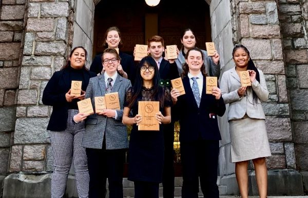 Speech team - group of 8 students holding plaques