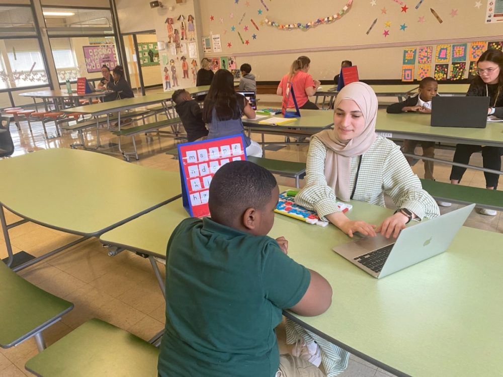 Niner University Elementary classroom with teacher and student at a table.